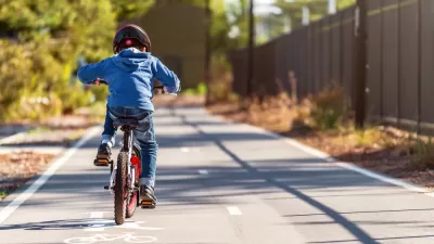 Small boy riding bike on two-way paved bike trail